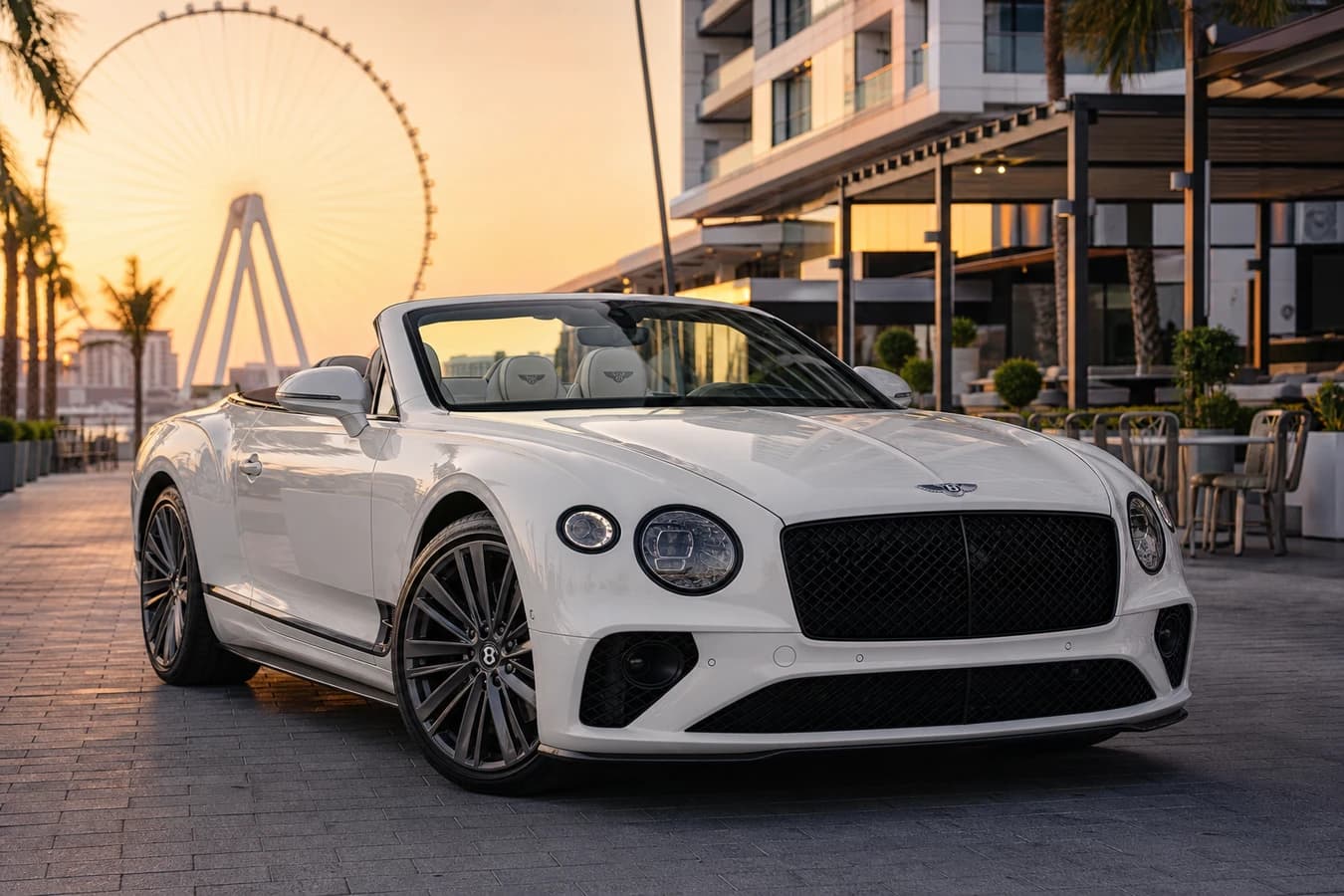 Best car to rent in Bluewaters Island hero with a Bentley Continental GTC on the waterfront dining promenade at golden hour