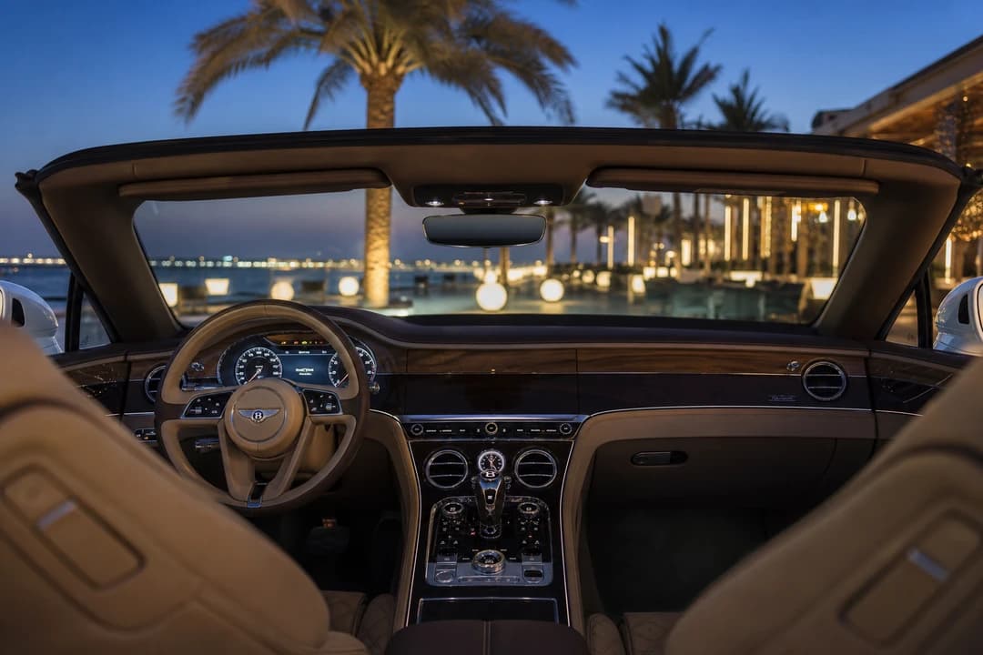 Bentley Continental GTC open-top cabin overlooking Bluewaters Island waterfront restaurants at dusk