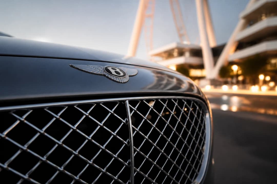 Bentley Continental GTC grille and winged B badge against Bluewaters Island architecture for Bluewaters Island car rental guide