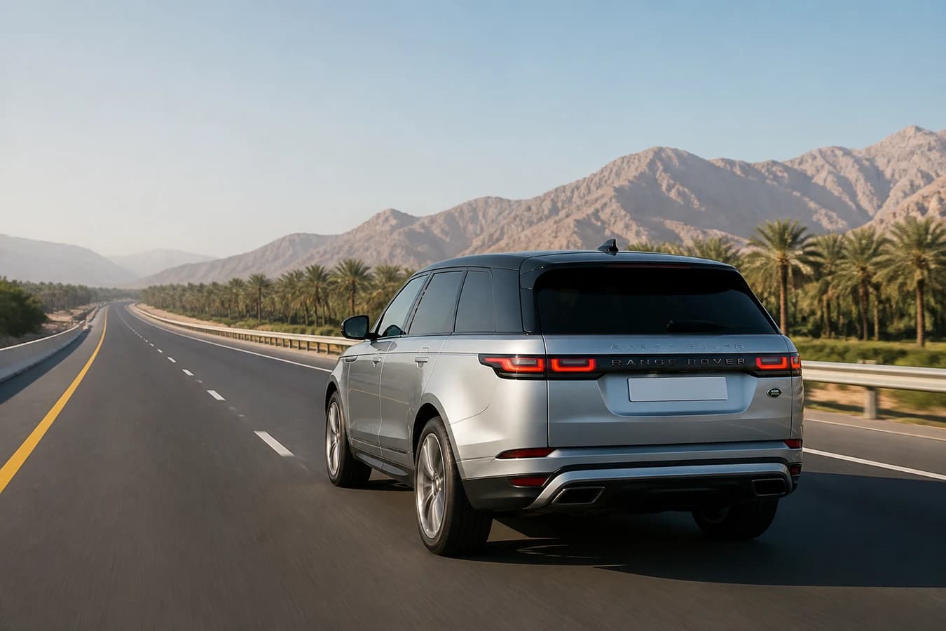 Dubai to Al Ain luxury car road trip: calm luxury SUV on a UAE dual carriageway toward Al Ain oasis hills at morning light