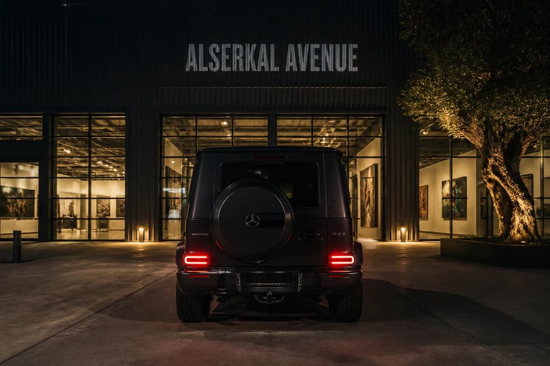 Best cars to rent Dubai in Alserkal: a dark SUV parked beside lit gallery doors for an evening opening