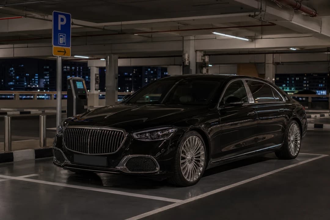 Dubai car hire parking at a mall at night beside paid-parking signage during Ramadan evening hours