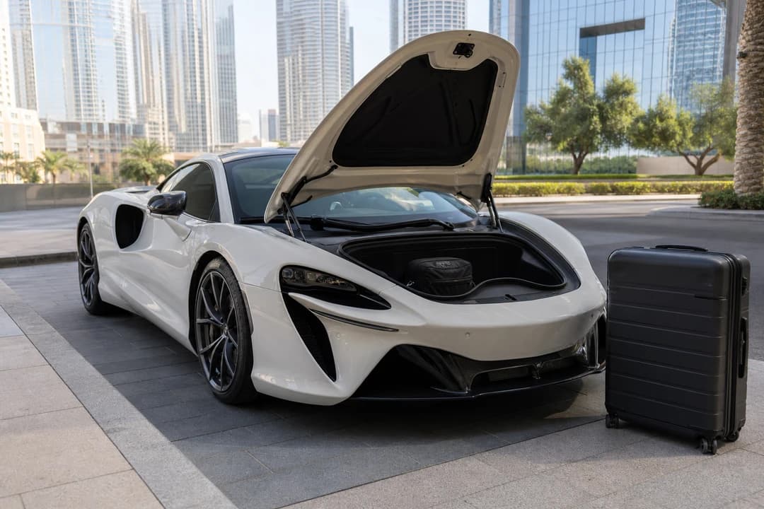 Silica white Artura frunk with one soft cabin bag and a rejected hard case at a Downtown hotel for luxury car rental Dubai packing