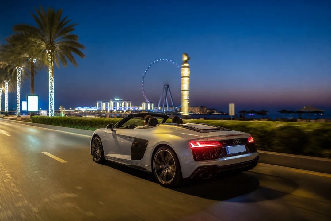 Audi R8 Spyder on JBR Beach Road at blue hour for exotic car rental Dubai first open-top evenings