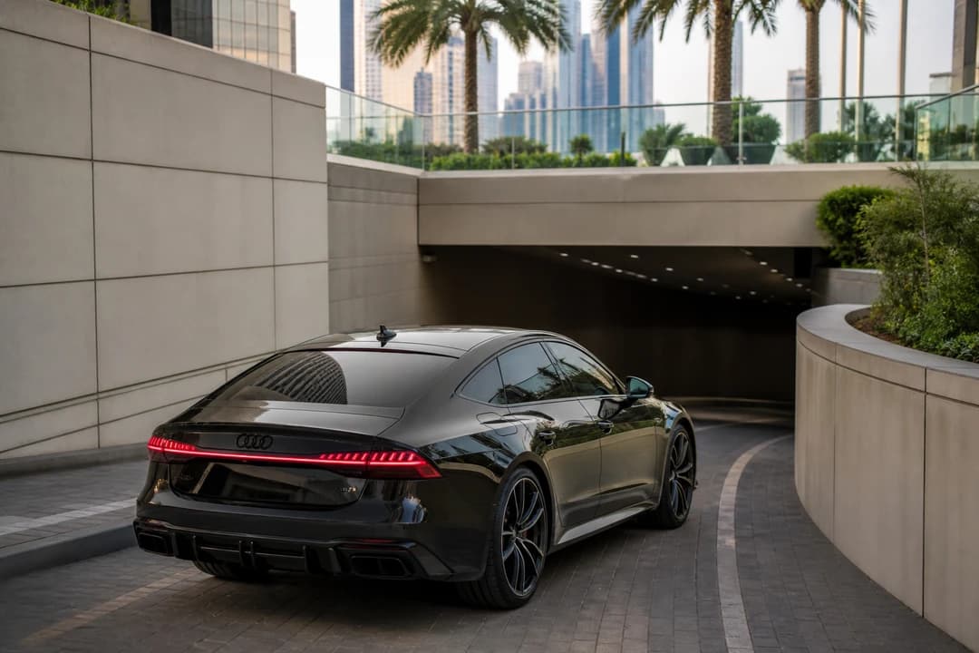 Rent Audi RS7 Dubai: long Sportback body approaching a hotel basement ramp for parking honesty