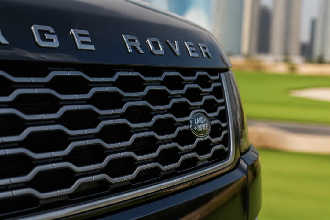 Range Rover grille detail with soft golf-course greenery for best car Dubai golf club identity