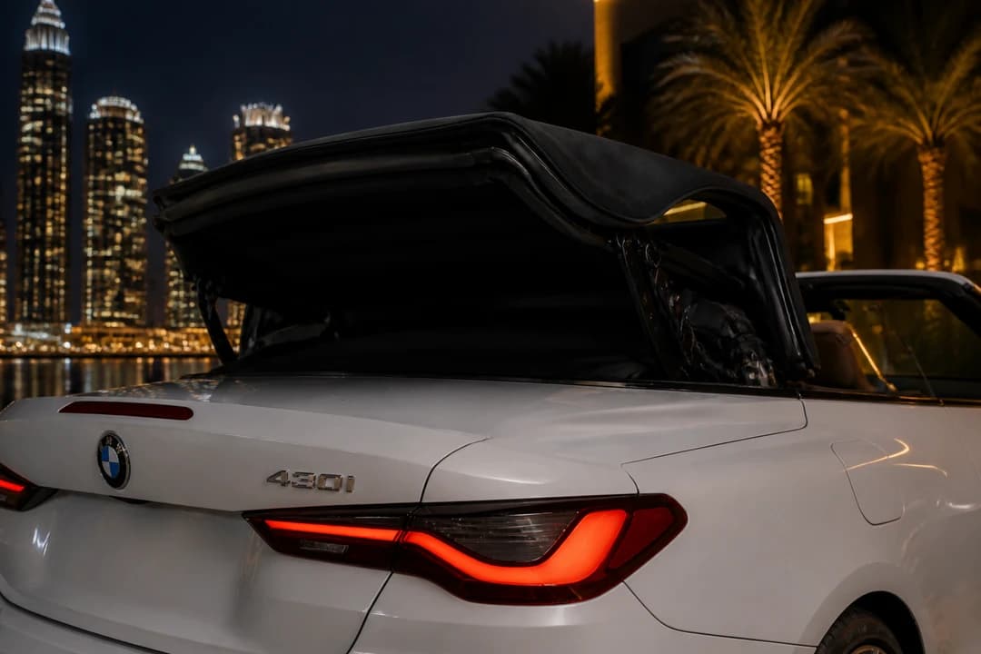 Convertible soft-top mechanism detail under Dubai night lights for open-top summer rental identity