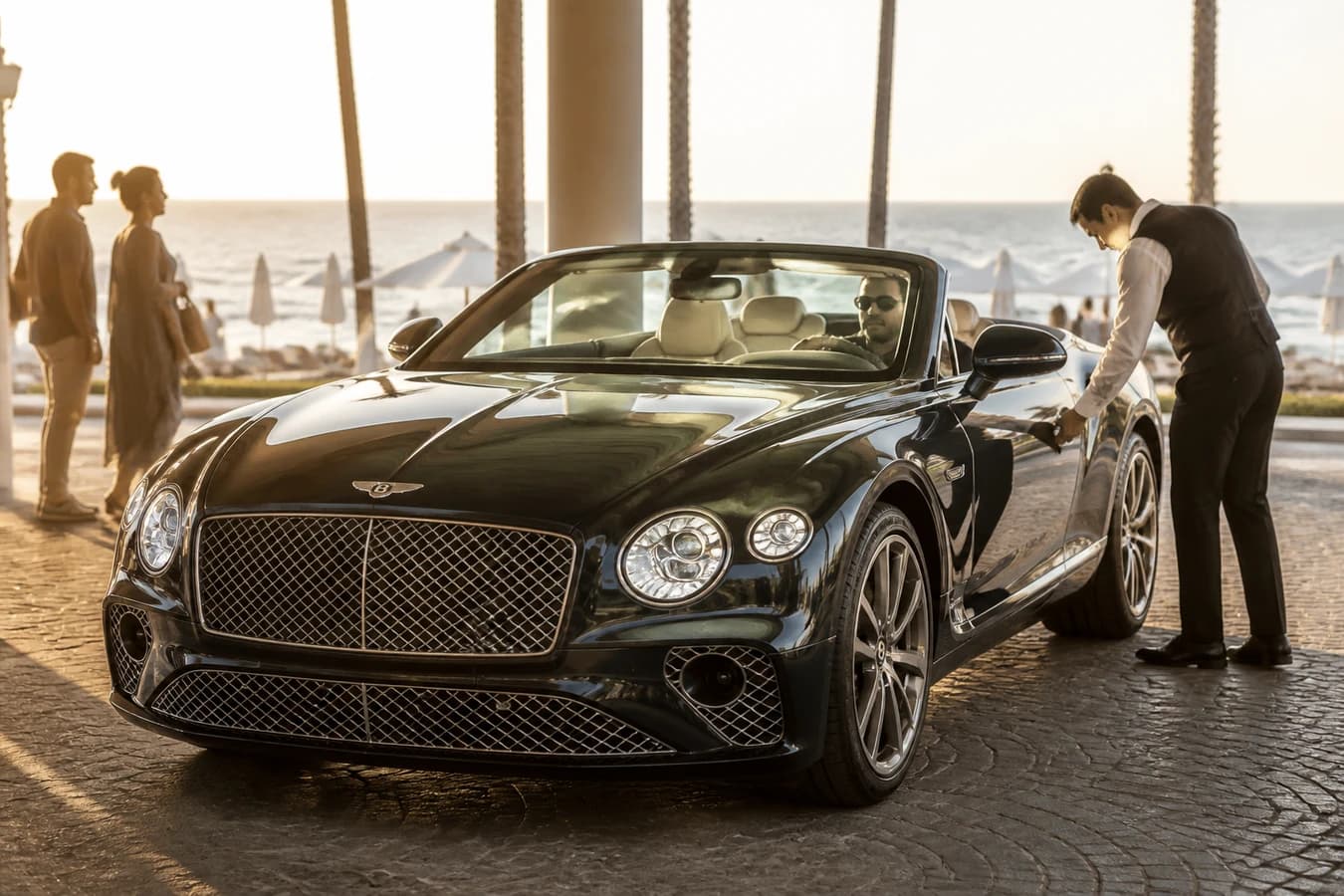 Best luxury car Dubai beach clubs hero with a Bentley Continental GTC at a waterfront club valet at golden hour