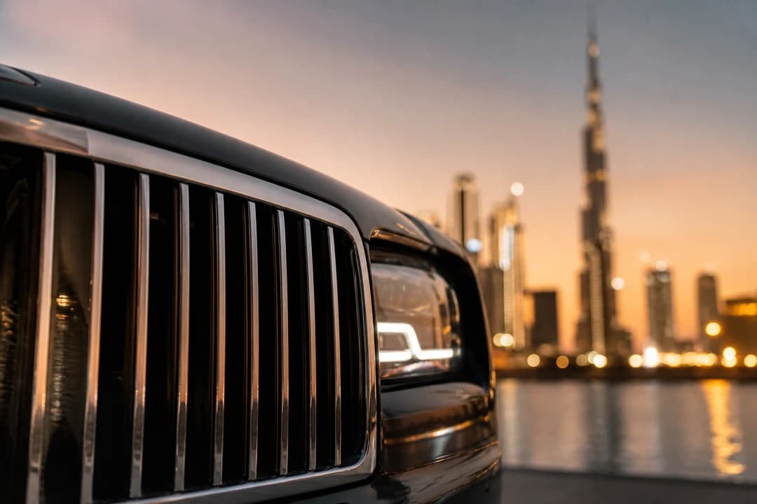 Luxury car grille detail with Dubai skyline bokeh for weekend luxury drive routes Dubai identity