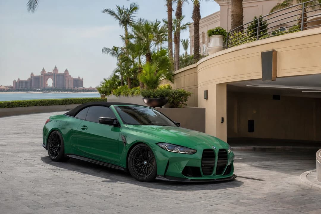 Rent BMW M4 Convertible Dubai: Isle of Man Green–style M4 cabriolet clearing a Palm Jumeirah hotel ramp