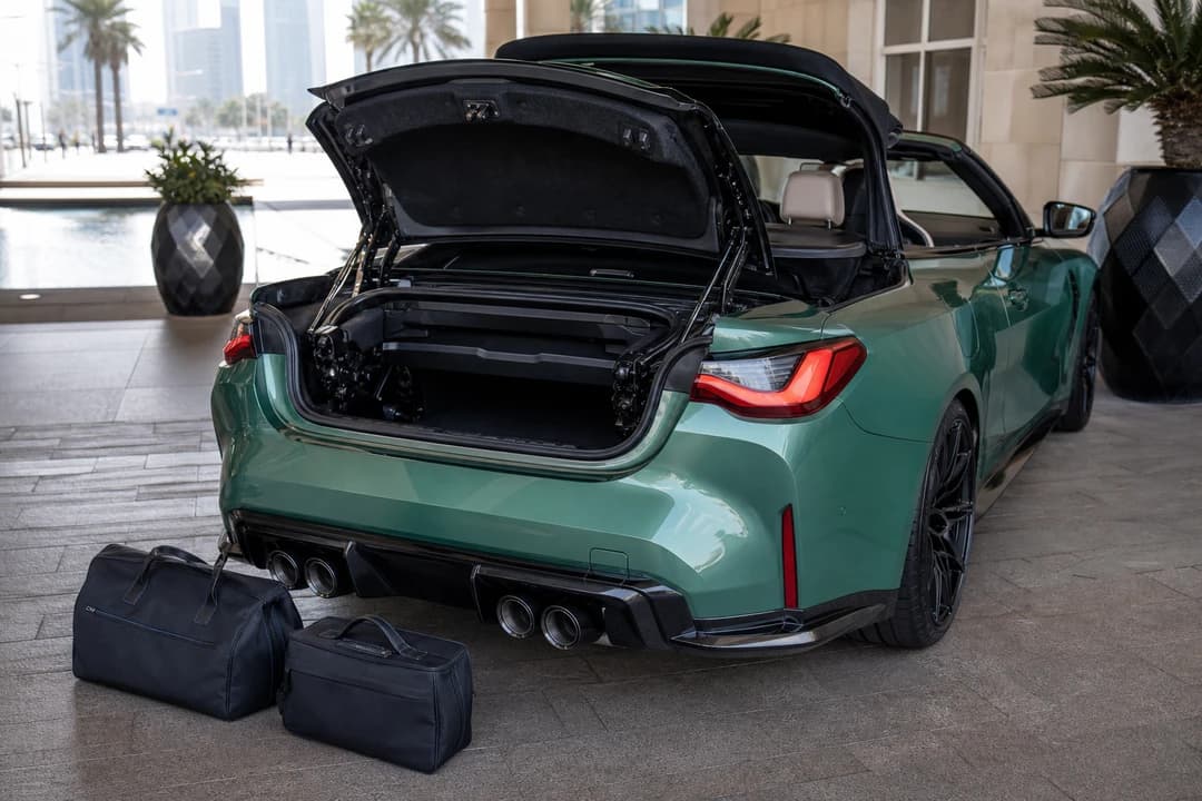 BMW M4 Convertible boot with soft cabin bags at a Dubai hotel driveway for luxury car rental Dubai packing