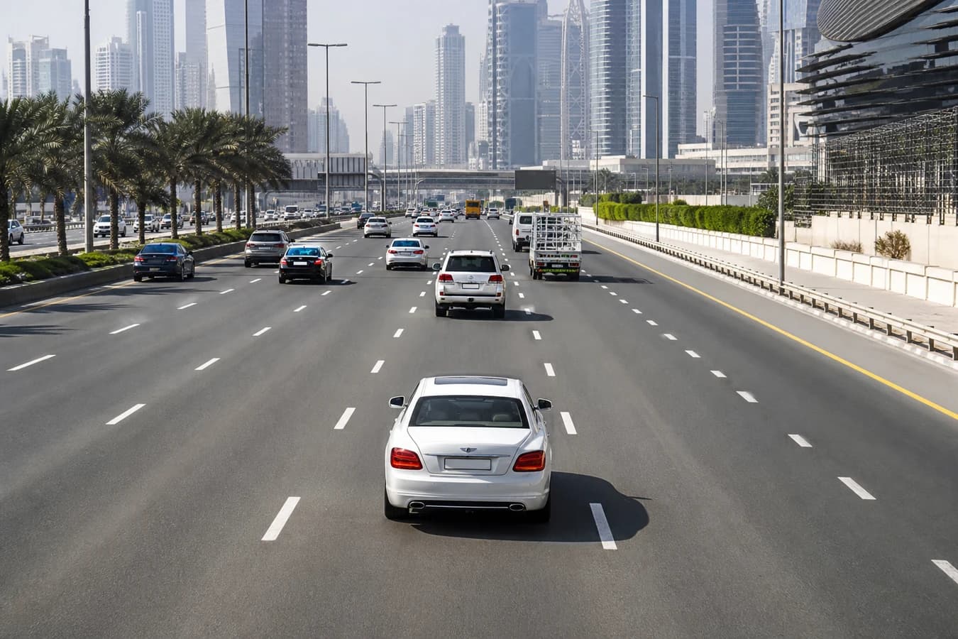 Dubai lane discipline rental car: multi-lane Sheikh Zayed Road carriageway with clear markings and calm luxury hire traffic in daylight
