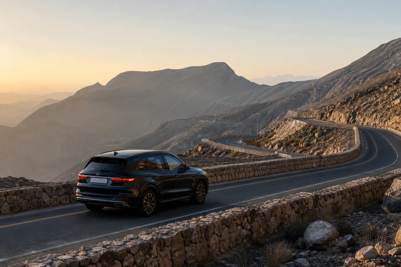 Dubai to Jebel Jais car rental road trip: luxury SUV climbing a Ras Al Khaimah mountain highway at morning