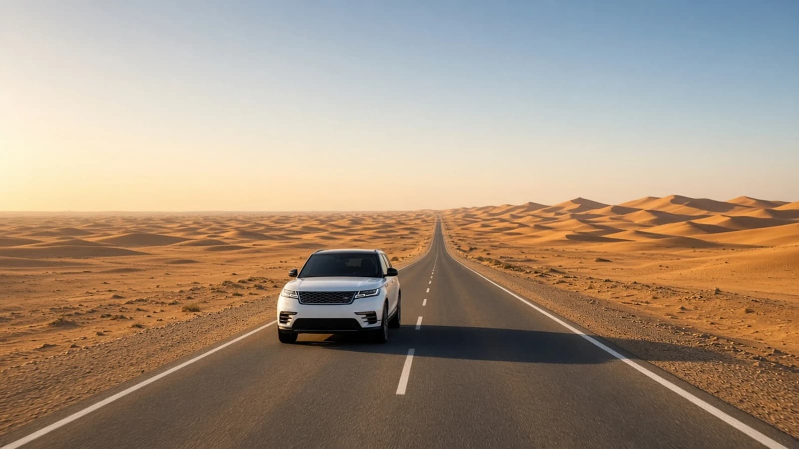 Dubai to Liwa luxury car rental: luxury SUV on a long sealed desert highway toward Empty Quarter dunes at golden hour