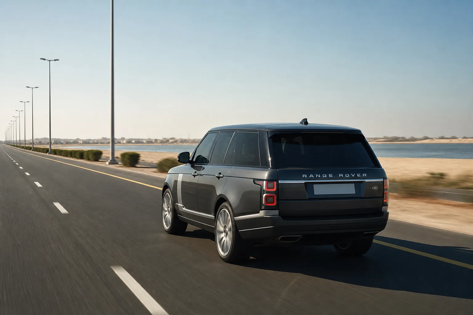 Dubai to Umm Al Quwain luxury car rental: luxury SUV on a northern UAE coastal dual carriageway at morning
