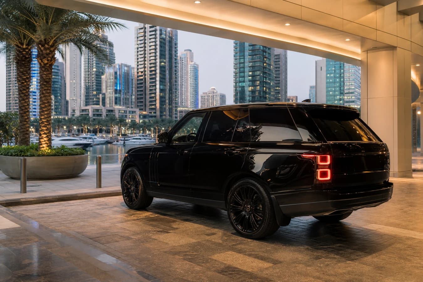 Dubai tourist season car rental: luxury SUV at a Marina hotel porte-cochère on a clear cool-season evening
