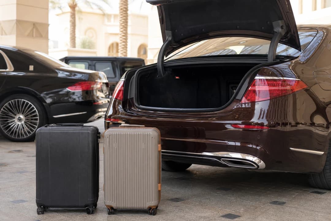Soft roller bags at a Dubai hotel valet comparing luggage fit for luxury car hire Dubai sedans