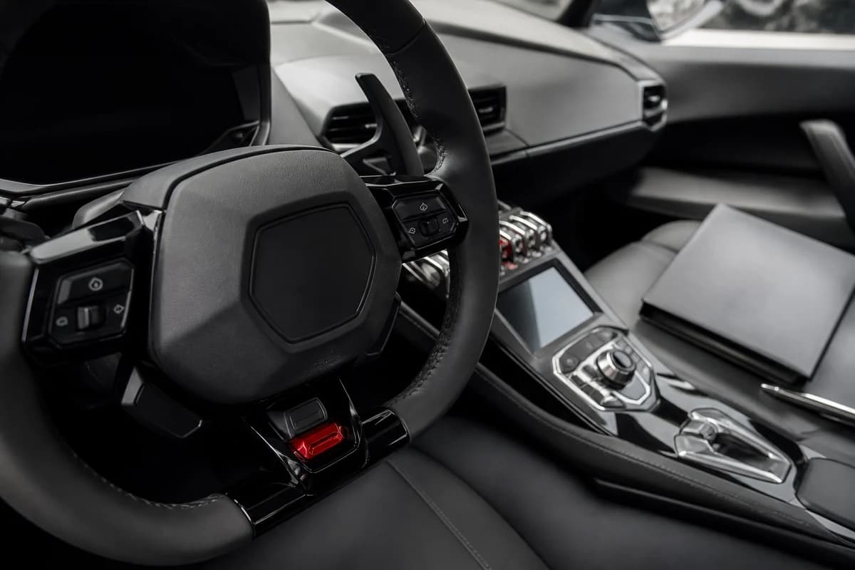 Lamborghini Huracan steering wheel and rental folder on the passenger seat before self-drive handover