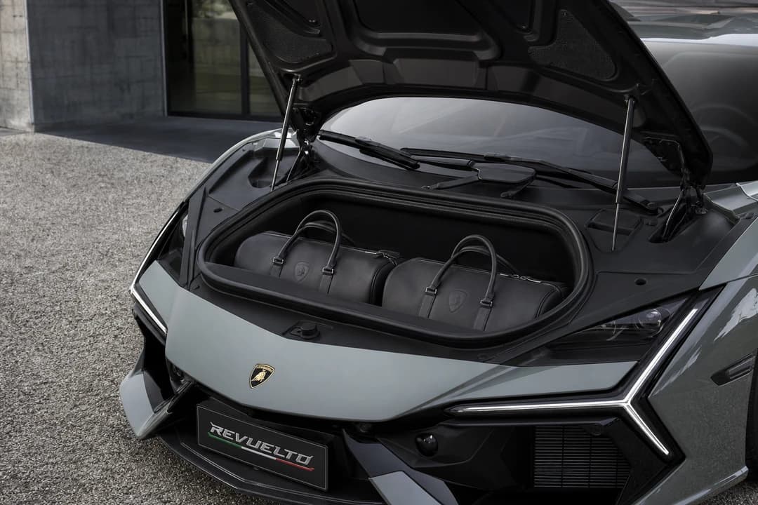 Lamborghini Revuelto front luggage compartment with soft weekend bags for a two-seat hypercar trip