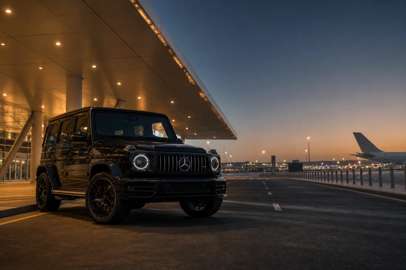 Luxury car rental Dubai South hero with a Mercedes-Benz G63 at Al Maktoum DWC airport at dusk