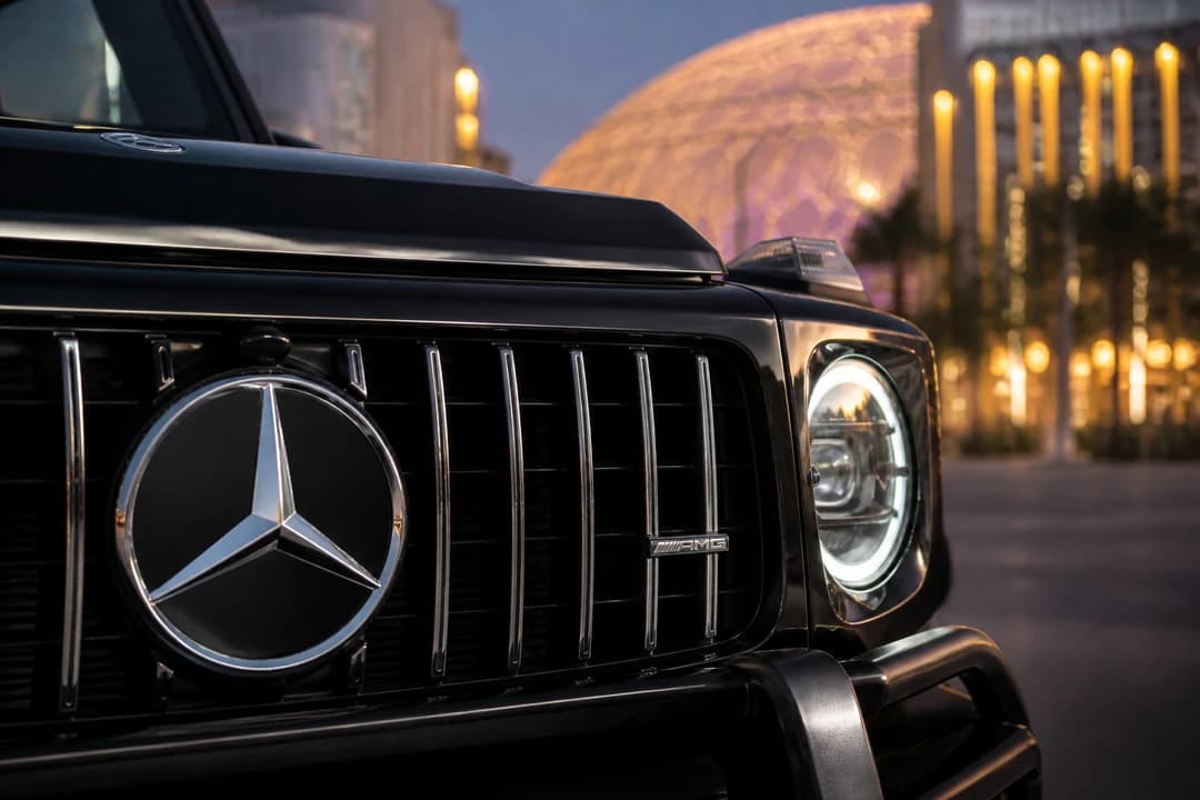 G63 grille detail at dusk with Expo City lights for luxury car rental Dubai South identity