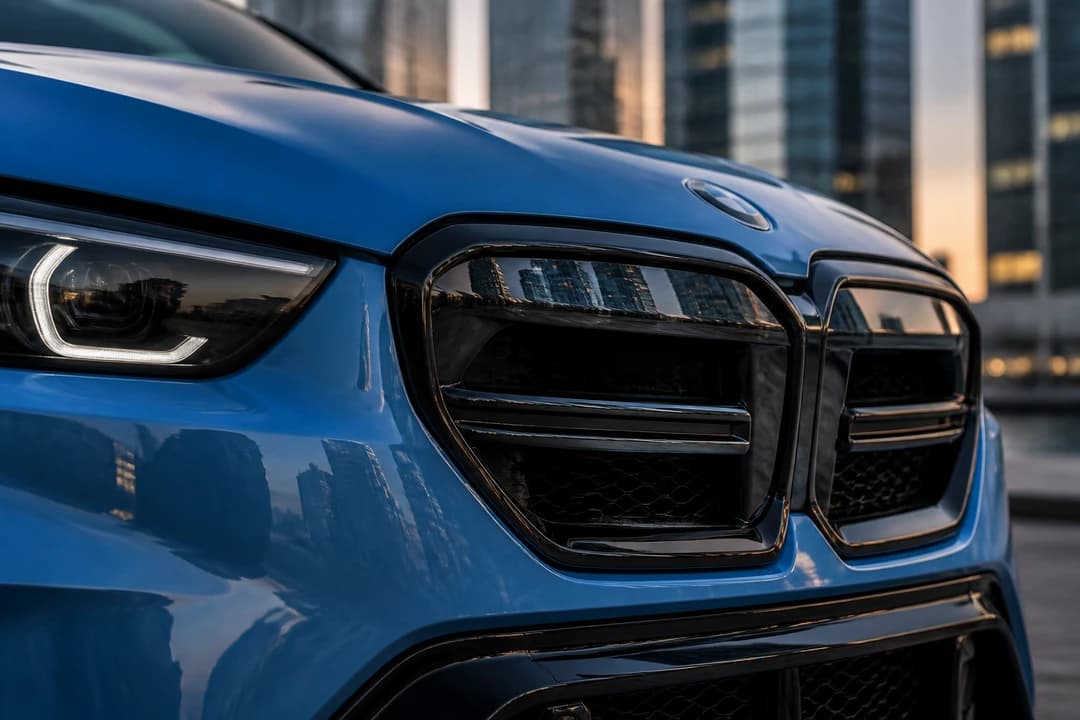 BMW M5 kidney grille detail with JLT tower glass reflections for best cars to rent Dubai shortlists
