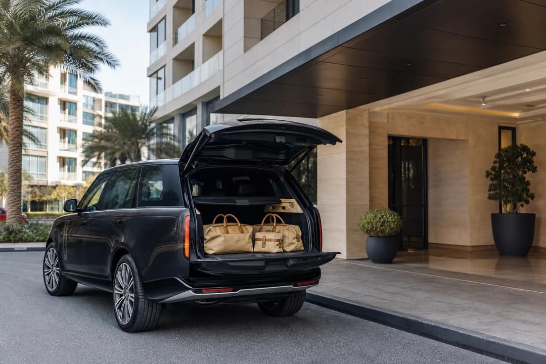 Range Rover at a Jumeirah Village Circle apartment entrance for luxury car rental Dubai stays