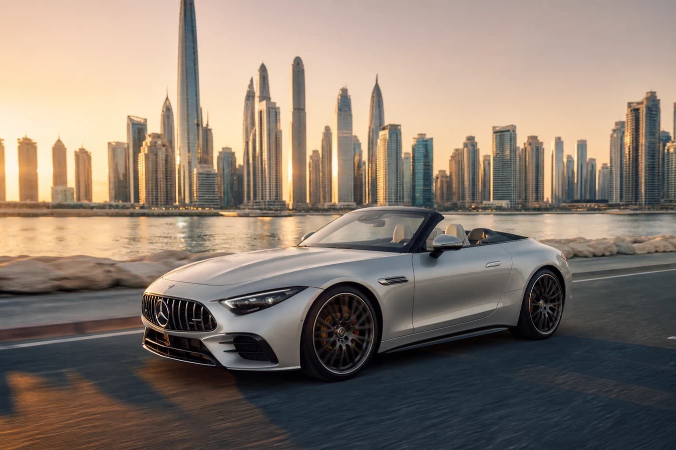 Mercedes SL43 rental Dubai: silver AMG roadster roof-down on a Marina coastal road at golden hour
