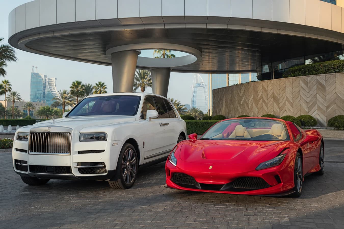 One car vs two cars Dubai rental hero with a luxury SUV and a convertible parked at a Dubai hotel porte-cochère
