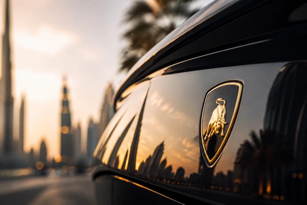 Luxury badge close-up reflecting Dubai skyline — prestige detail in a renting vs buying luxury car Dubai decision