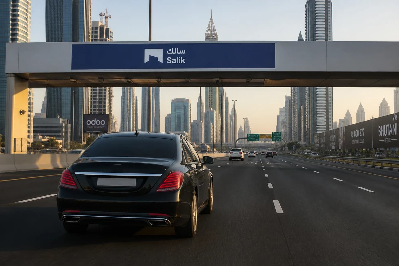 Salik rental car Dubai: luxury sedan approaching a Salik toll gantry on Sheikh Zayed Road