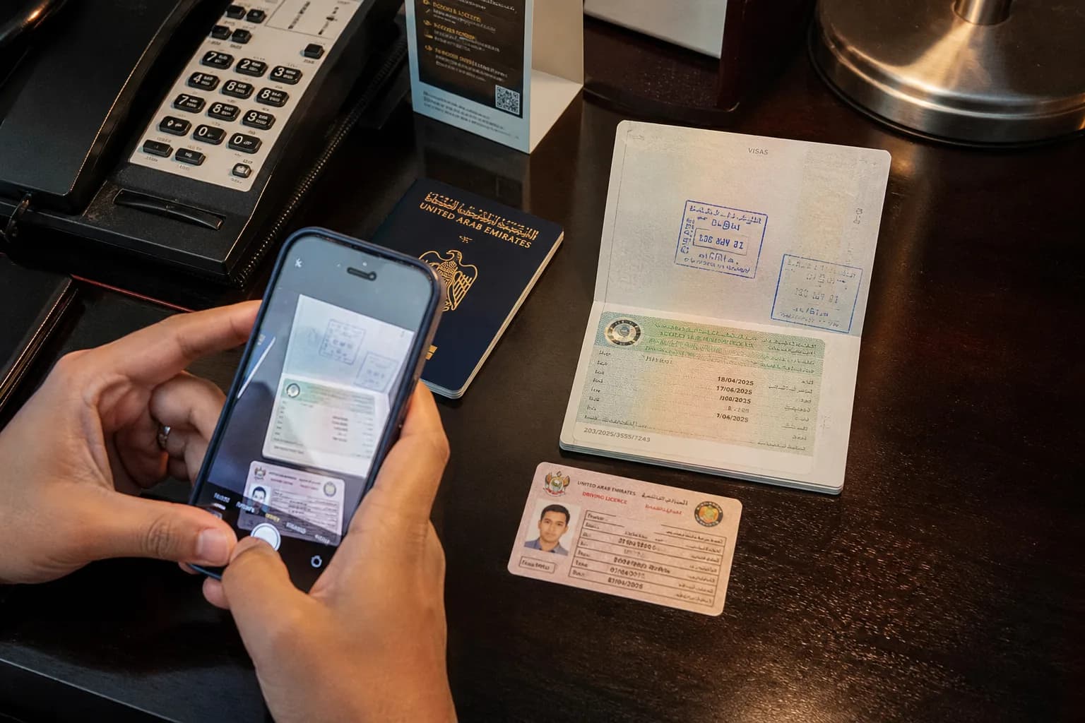 Passport, licence, and phone photographing documents for fast Dubai car rental guide approval