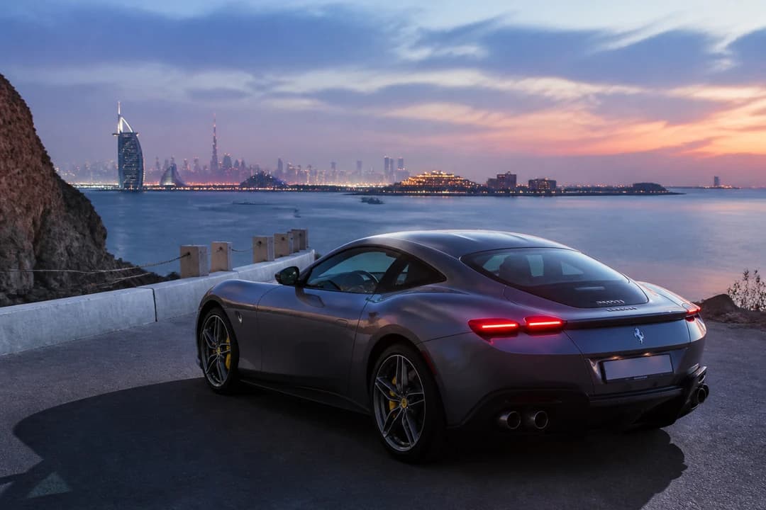 Grand tourer coupe at a UAE coastal viewpoint during a National Day long-weekend evening drive
