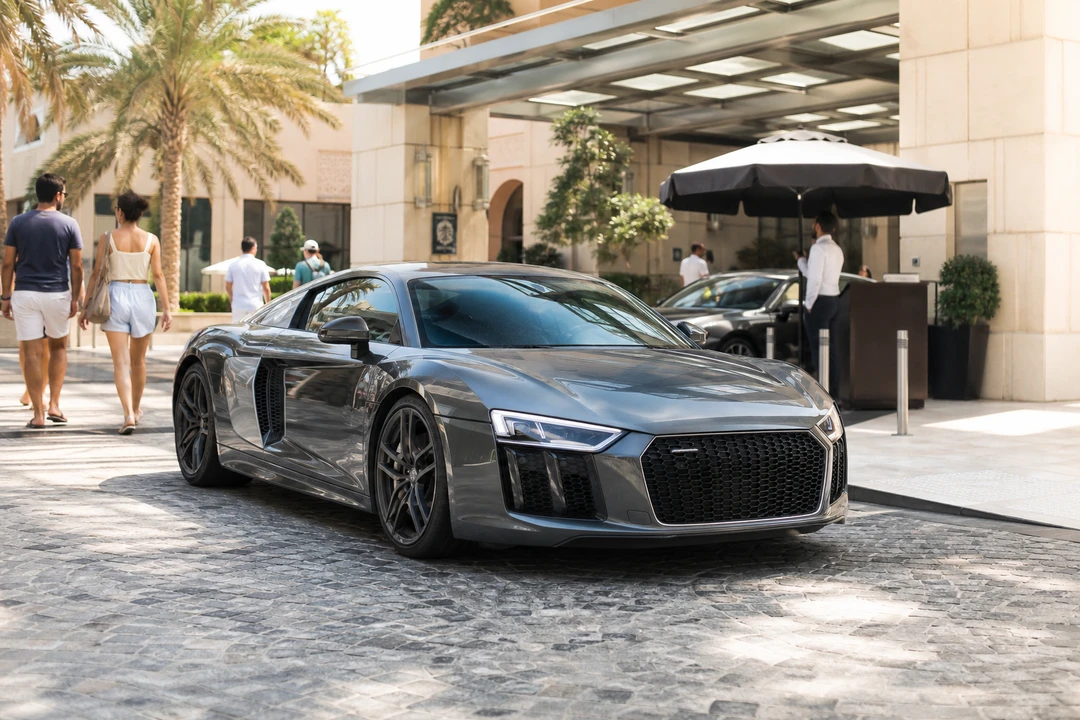 Audi R8 V10 coupe at a JBR hotel porte-cochère in morning light for rent Audi R8 Dubai hotel weeks