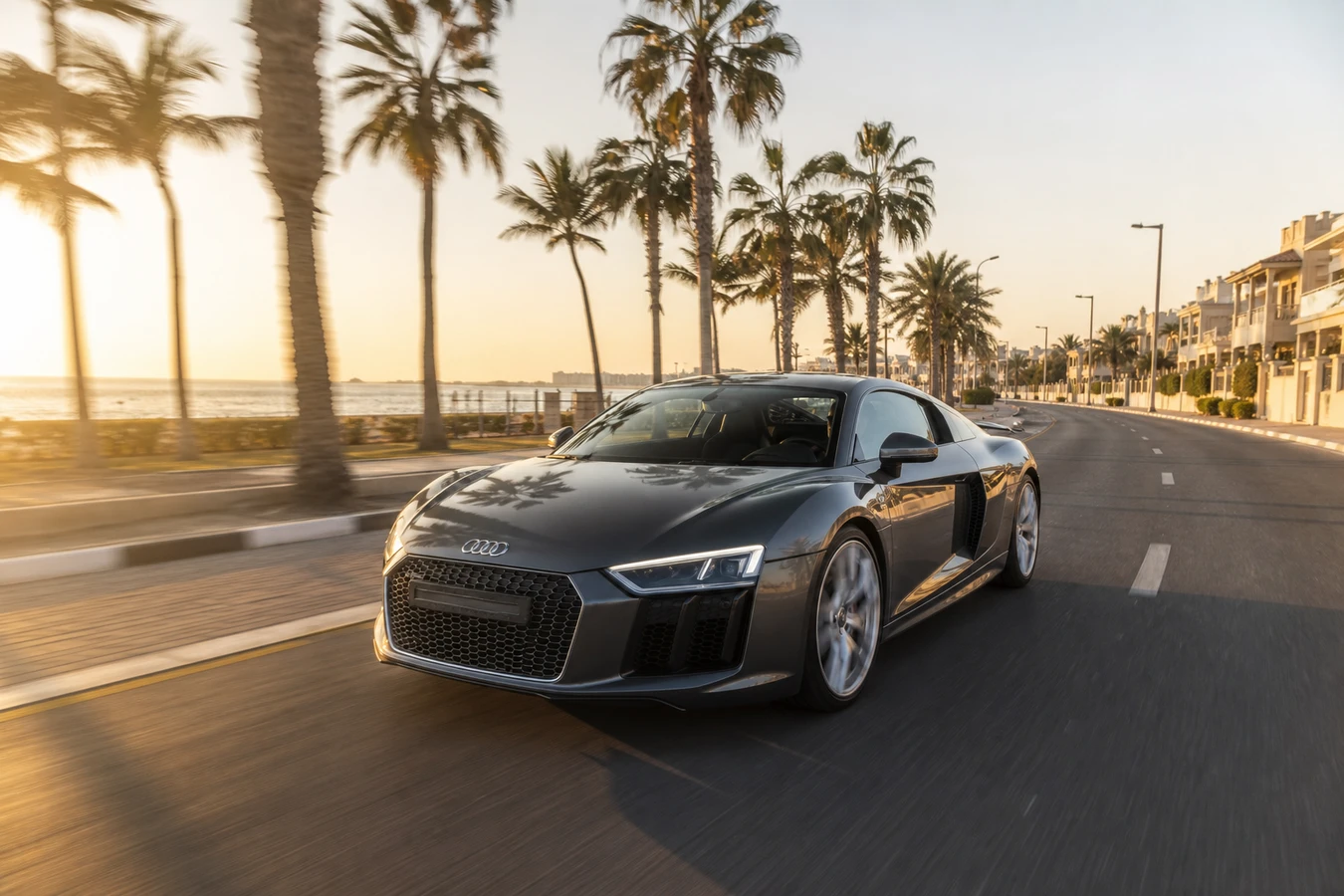 Audi R8 rental Dubai guide hero with a grey R8 V10 coupe on Jumeirah Beach Road at late afternoon