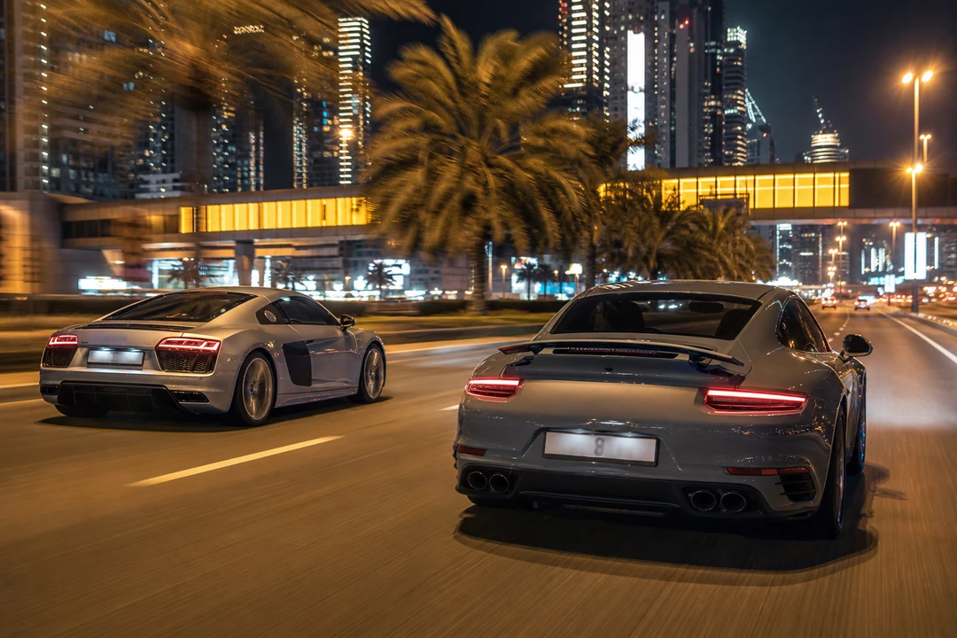 Audi R8 and Porsche 911 on Sheikh Zayed Road Dubai at night for supercar rental Dubai luxury car comparison Dubai