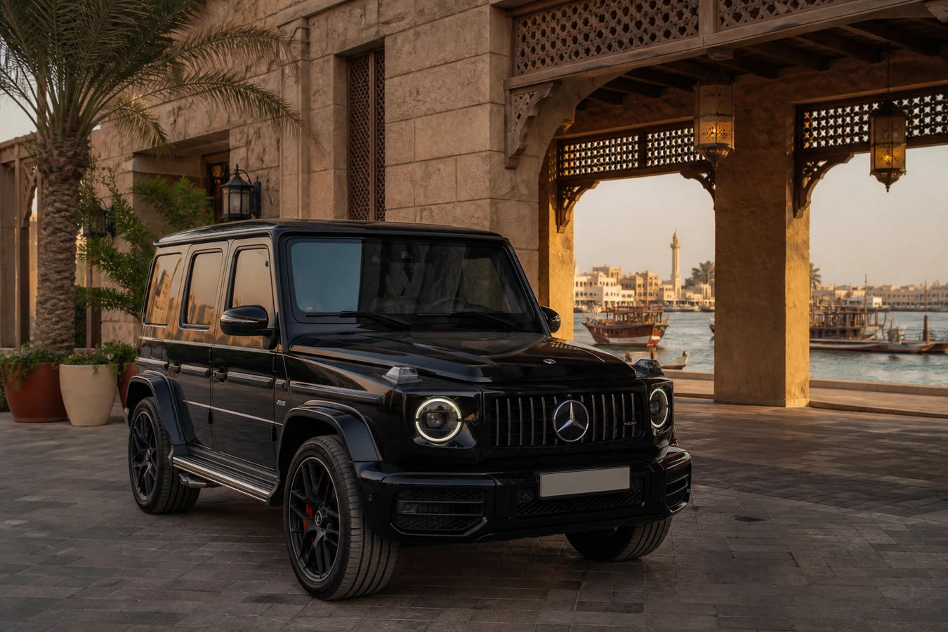 Car rental Deira Dubai luxury hero with a Mercedes-Benz G63 at an old Dubai Creek hotel beside traditional dhows