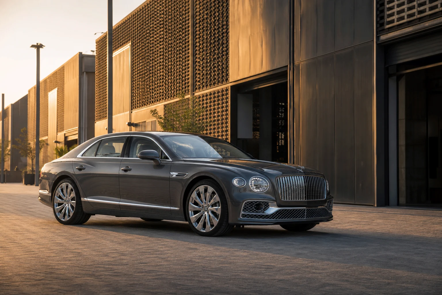 Luxury car rental Dubai Design District hero with a Bentley Flying Spur at d3 warehouse architecture in golden hour