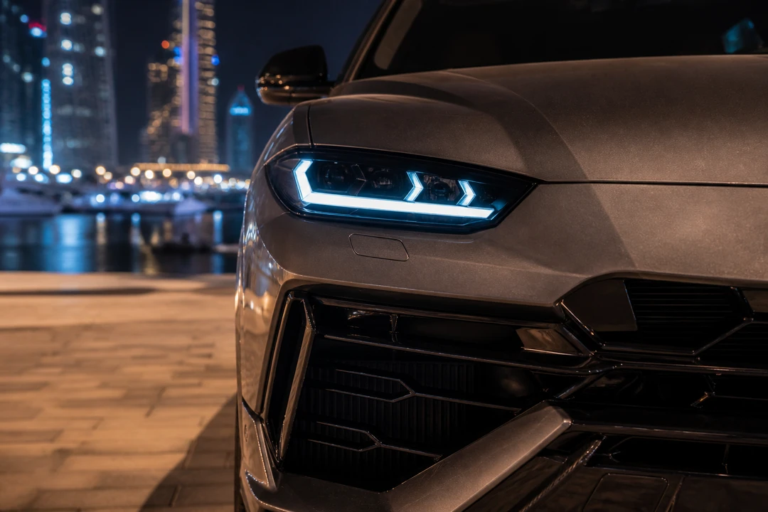 Lamborghini Urus grille detail against Dubai Harbour waterfront lights for UAE road trip rental presence