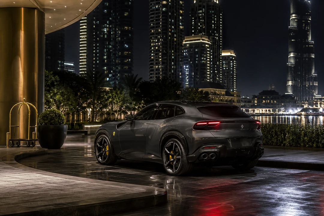 Ferrari Purosangue at Downtown Dubai towers at night for Ferrari car rental Dubai arrivals