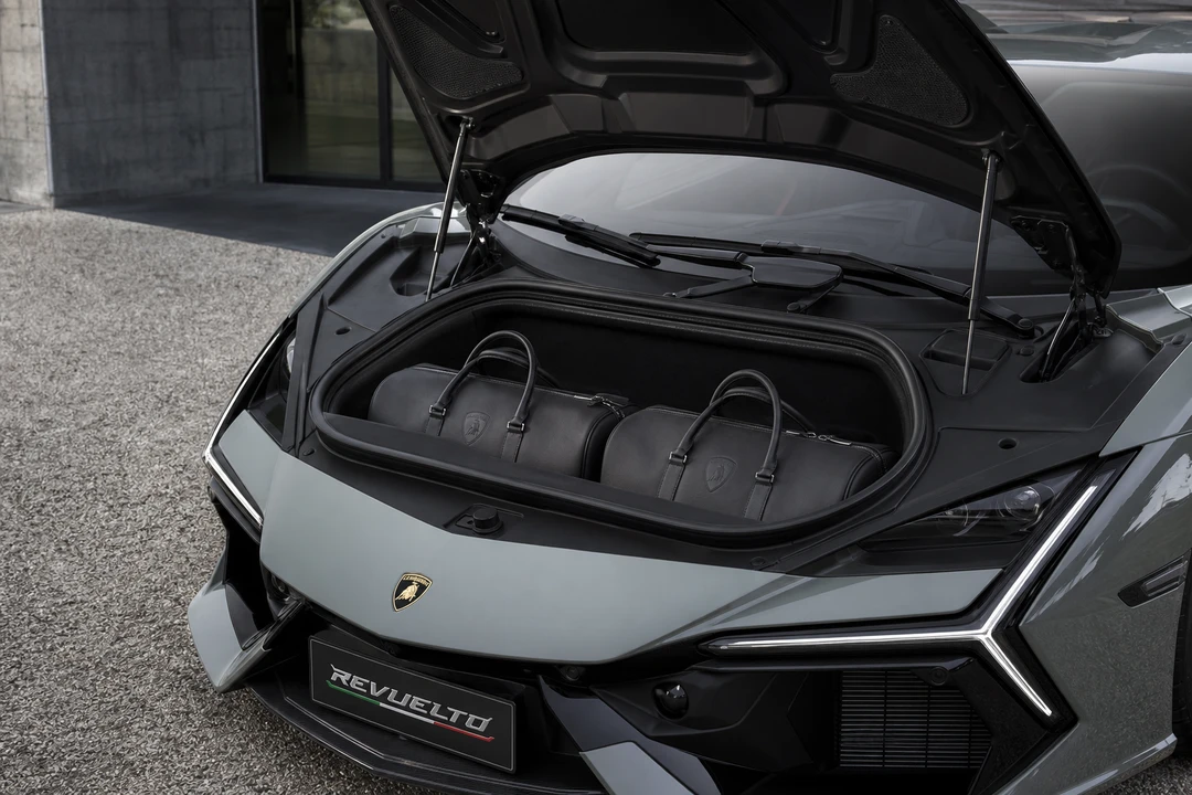 Lamborghini Revuelto front luggage compartment with soft weekend bags for a two-seat hypercar trip