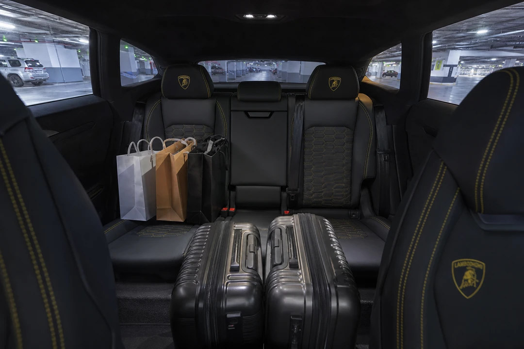 Lamborghini Urus rear cabin with shopping bags and carry-on luggage for mall and meeting errands