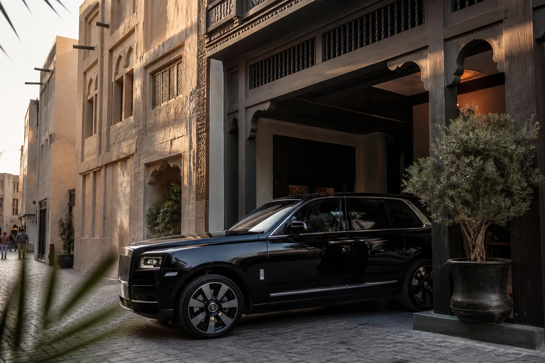 Luxury SUV exterior at a Bur Dubai old-hotel porte-cochere for luxury car rental Bur Dubai