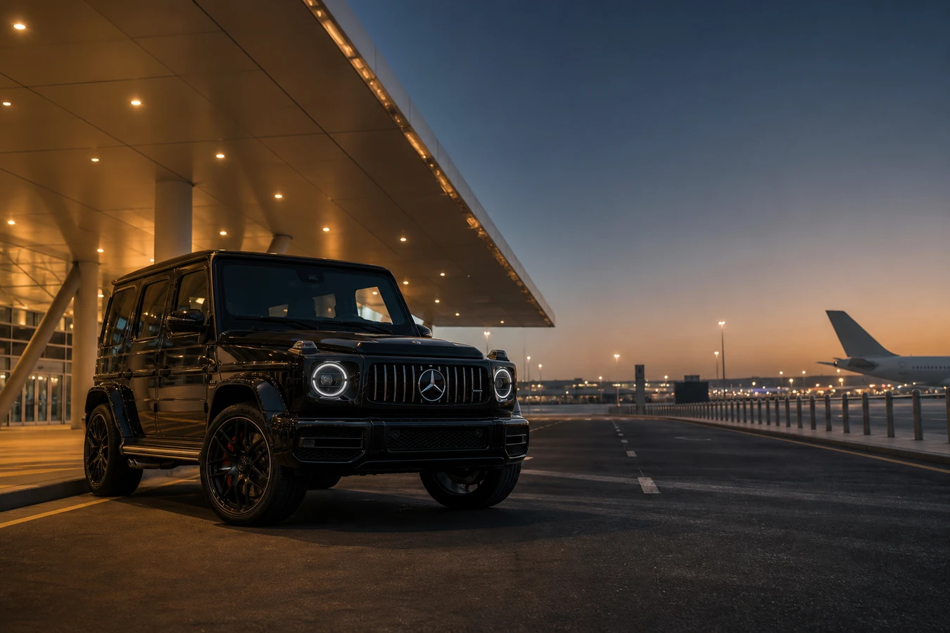 Luxury car rental Dubai South hero with a Mercedes-Benz G63 at Al Maktoum DWC airport at dusk